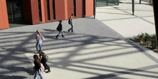 Passants traversant la cour intérieure d'un établissement d'enseignement